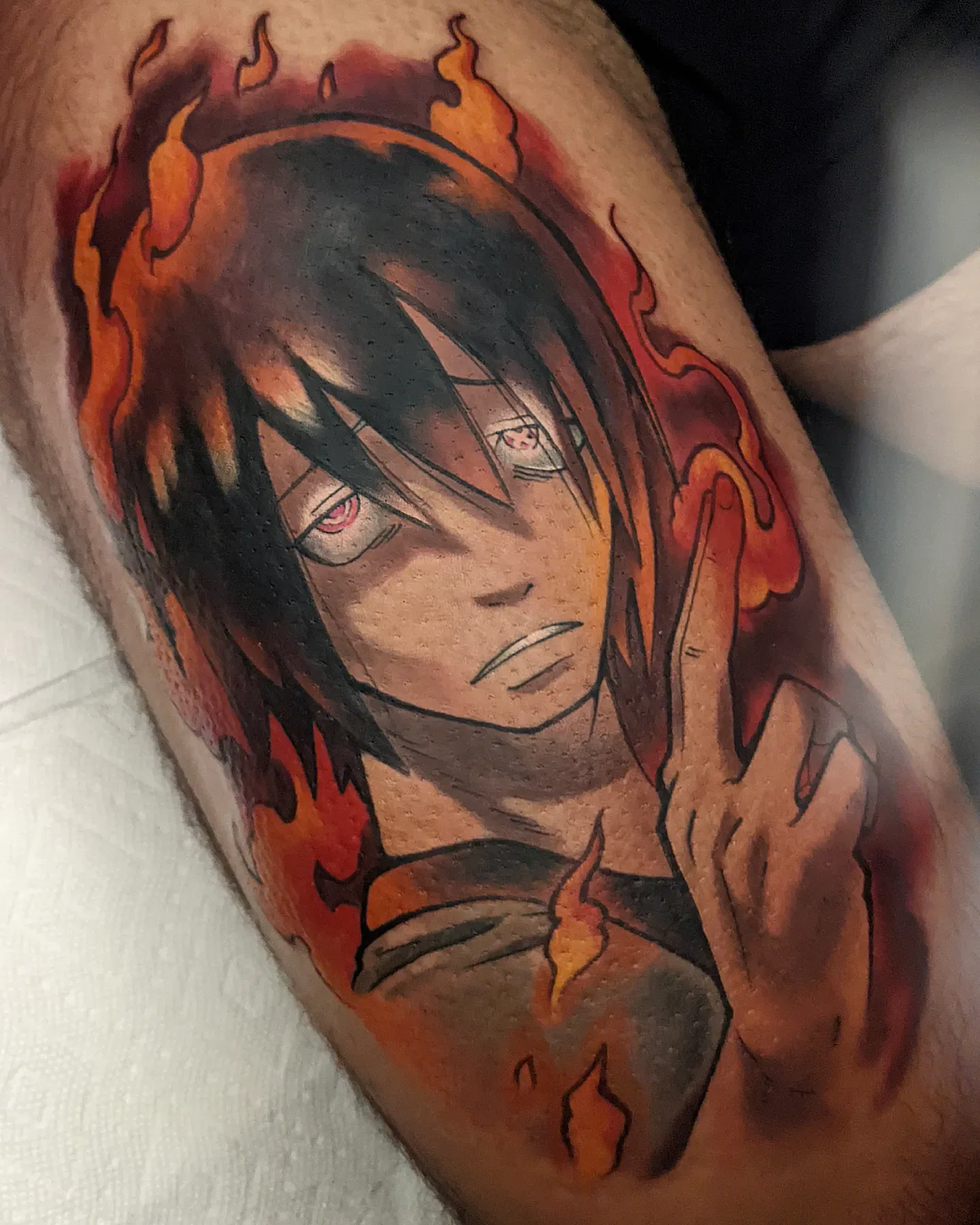 Anime character flame hair bicep tattoo raleigh