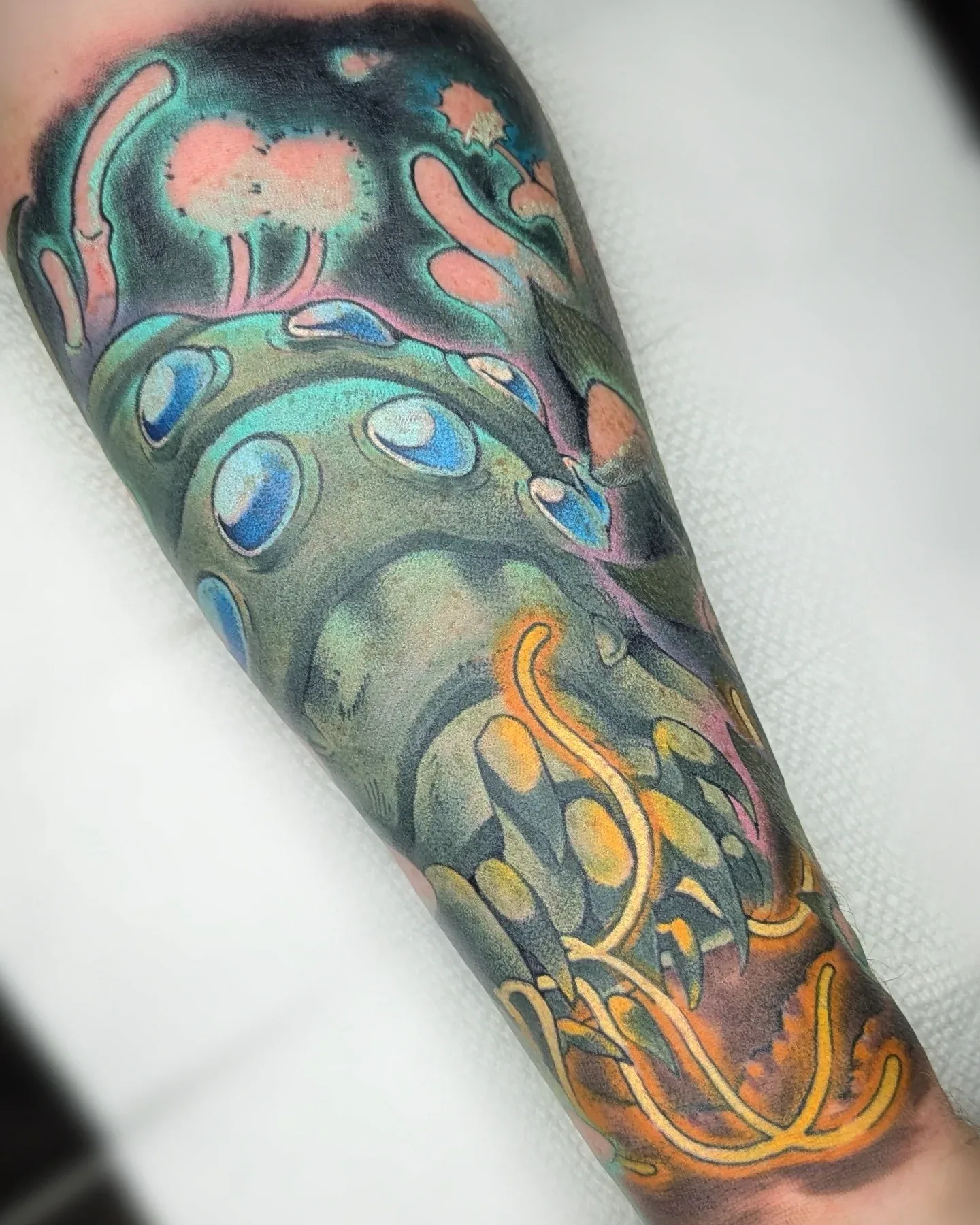 Color creature eyespots tendrils forearm tattoo raleigh