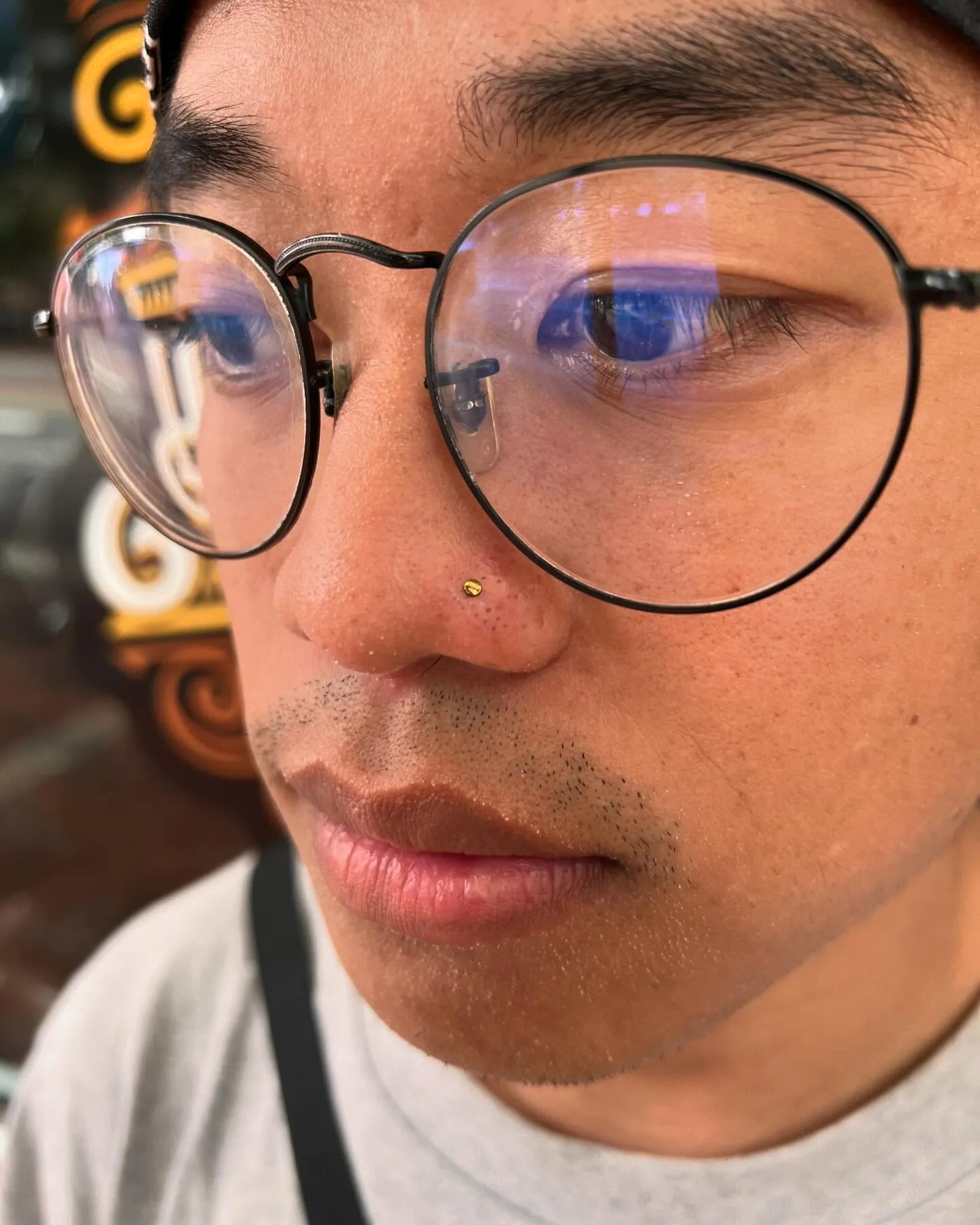 Close up nose piercing gold stud raleigh