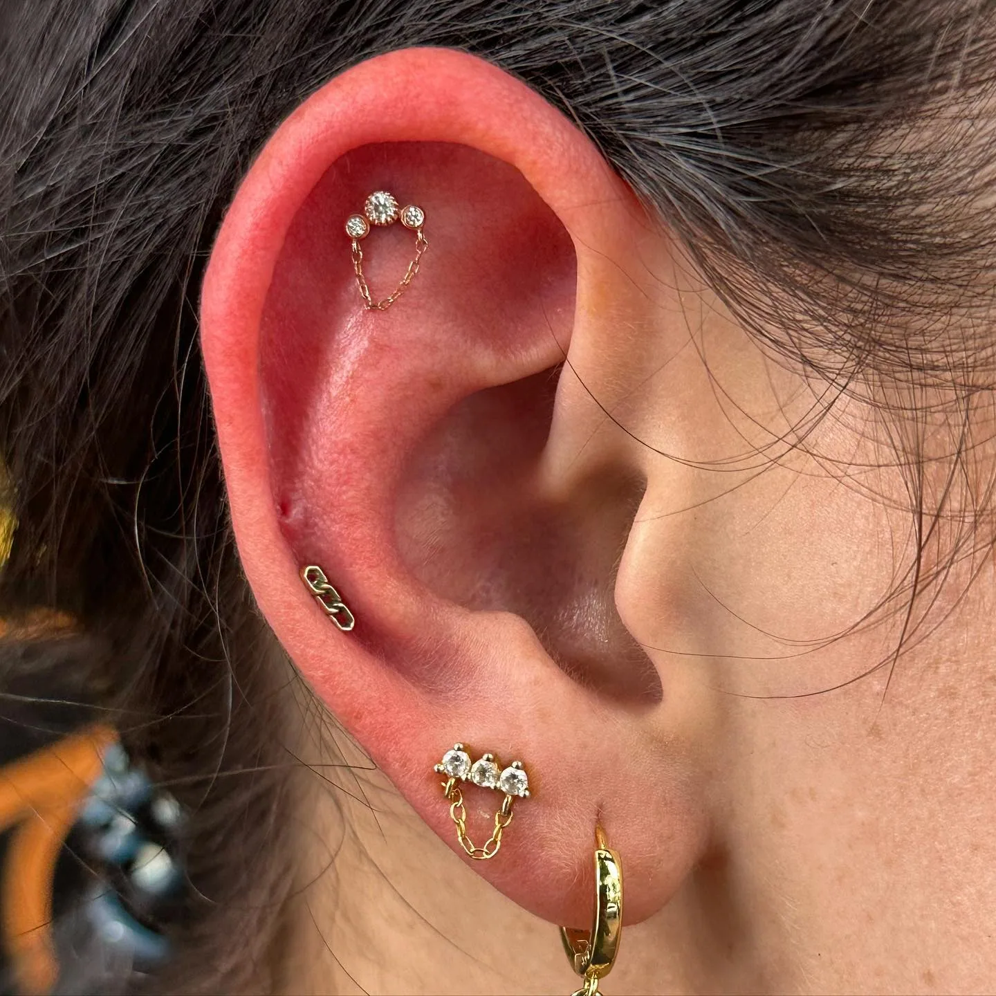 Gold chain cluster ear piercings raleigh