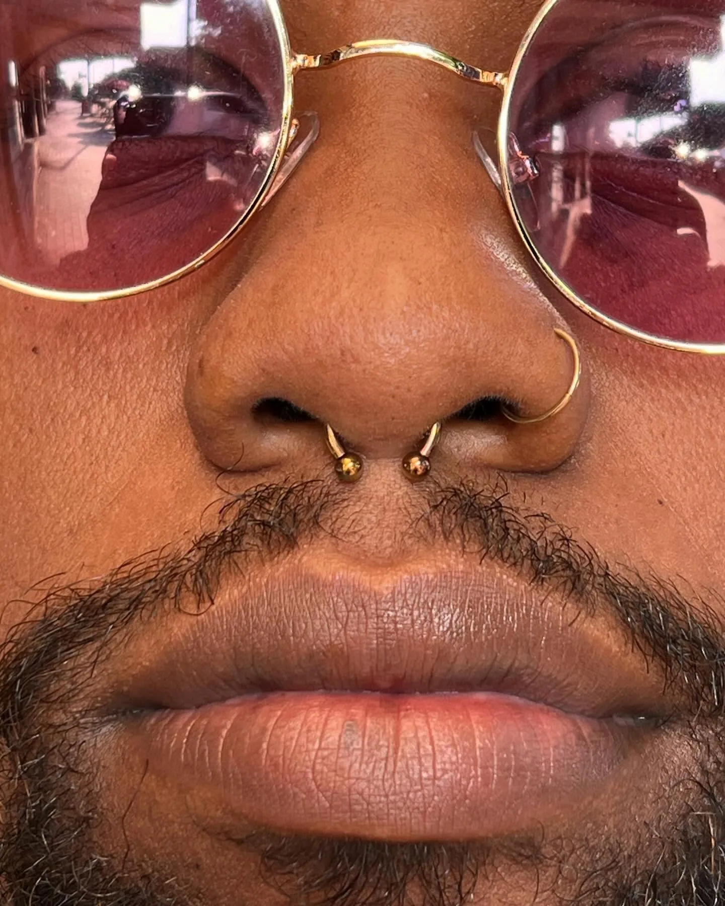 Gold septril nostril piercing closeup raleigh
