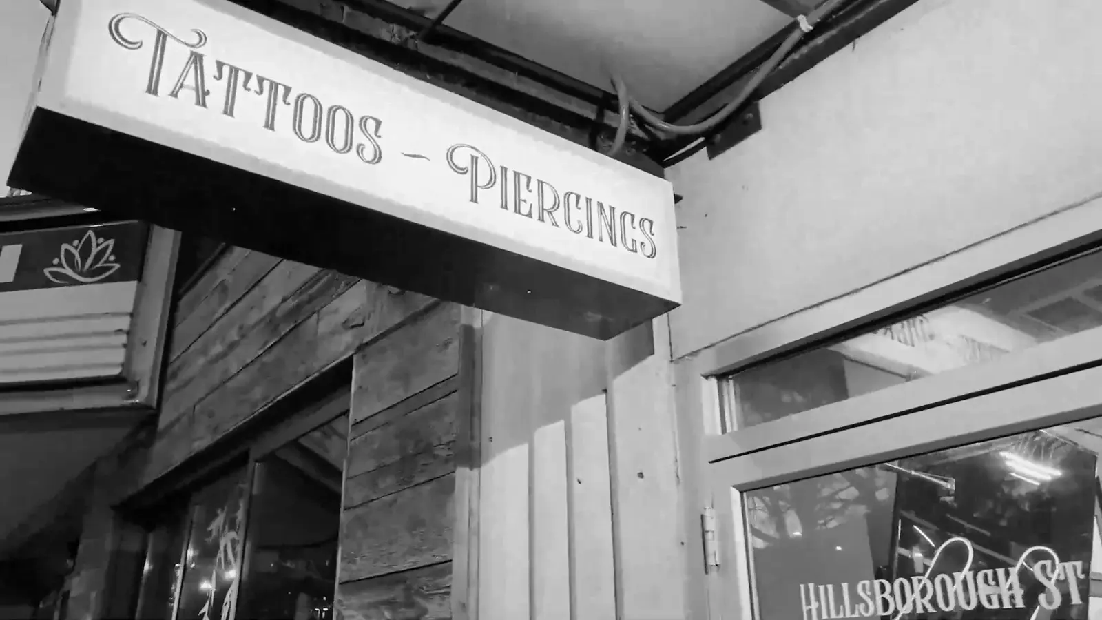 The Tattoos and Piercings sign outside Hillsborough St Tattoo in Raleigh